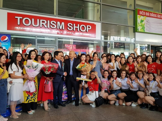 Lãnh đạo Sở Du lịch TP.Đà Nẵng tặng hoa đón đoàn khách MICE 700 người từ Hà Nội tại Sân bay Đà Nẵng sáng 22.1.2021. Ảnh: THU CÚC
