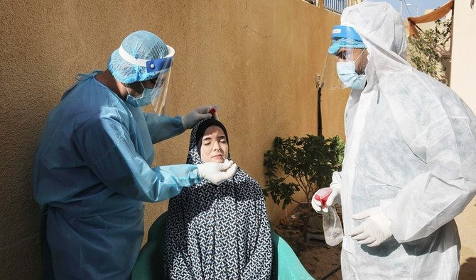 Nhân viên y tế Palestine lấy mẫu xét nghiệm corona cho một người dân ở phía nam Dải Gaza. Ảnh: AFP