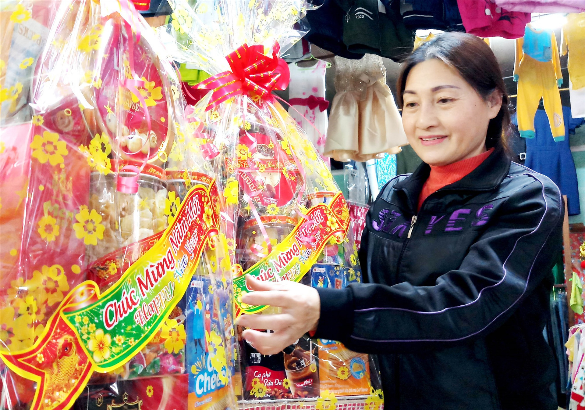 Vắng khách, thời gian gần đây, bà Nguyễn Thị Sâm - chủ tạp hóa Sâm Thông nhận gói những giỏ bánh kẹo được cơ quan, đơn vị đặt làm quà biếu. Ảnh: ĐĂNG NGUYÊN