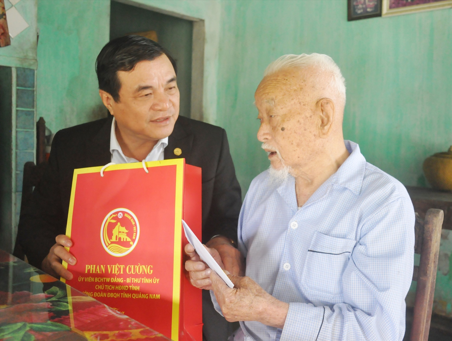 Ủy viên Trung ương Đảng, Bí thư Tỉnh ủy Phan Việt Cường tặng quà chúc tết ông Đỗ Nhuận. Ảnh: N.Đ