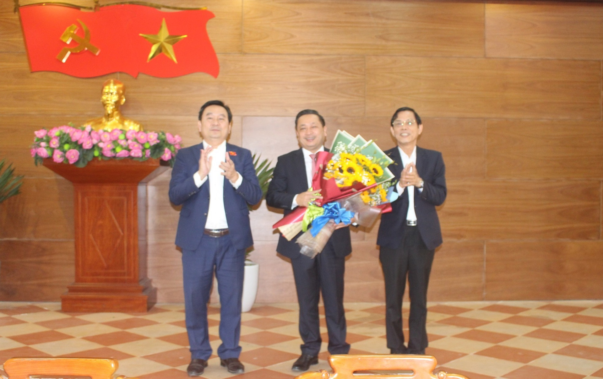 Trưởng ban Tổ chức Tỉnh ủy Nguyễn Chín (bên phải) tặng hoa chúc mừng đồng chí Nguyễn Hảo. Ảnh: NHẬT DUY