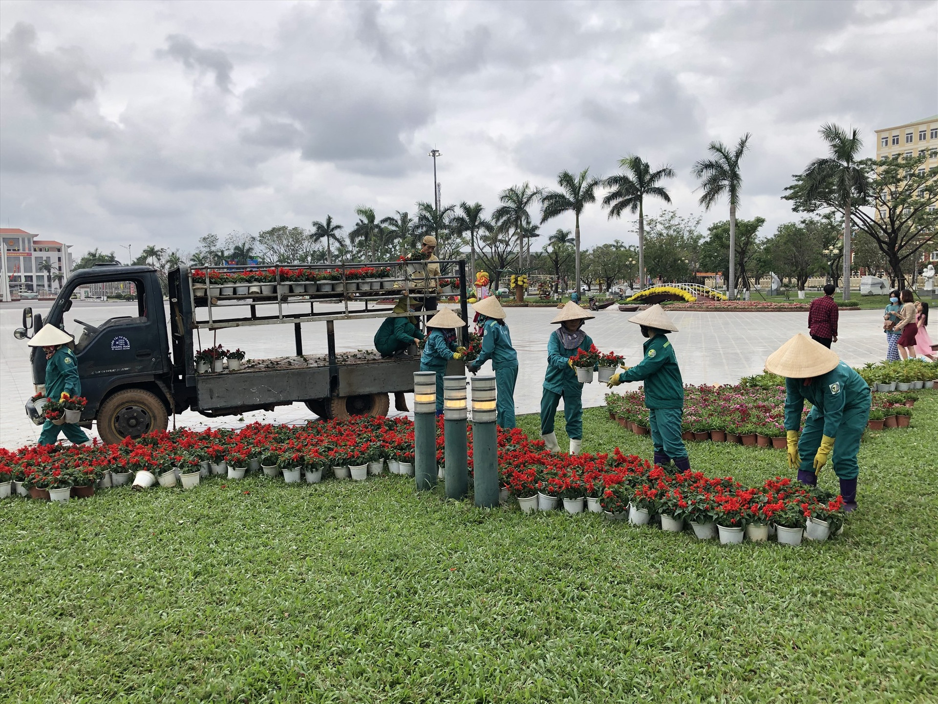Các nữ công nhân đang làm nhiệm vụ chăm sóc hoa tại công viên Quảng trường 24.3 TP.Tam Kỳ. Ảnh: TRÚC TRẦN