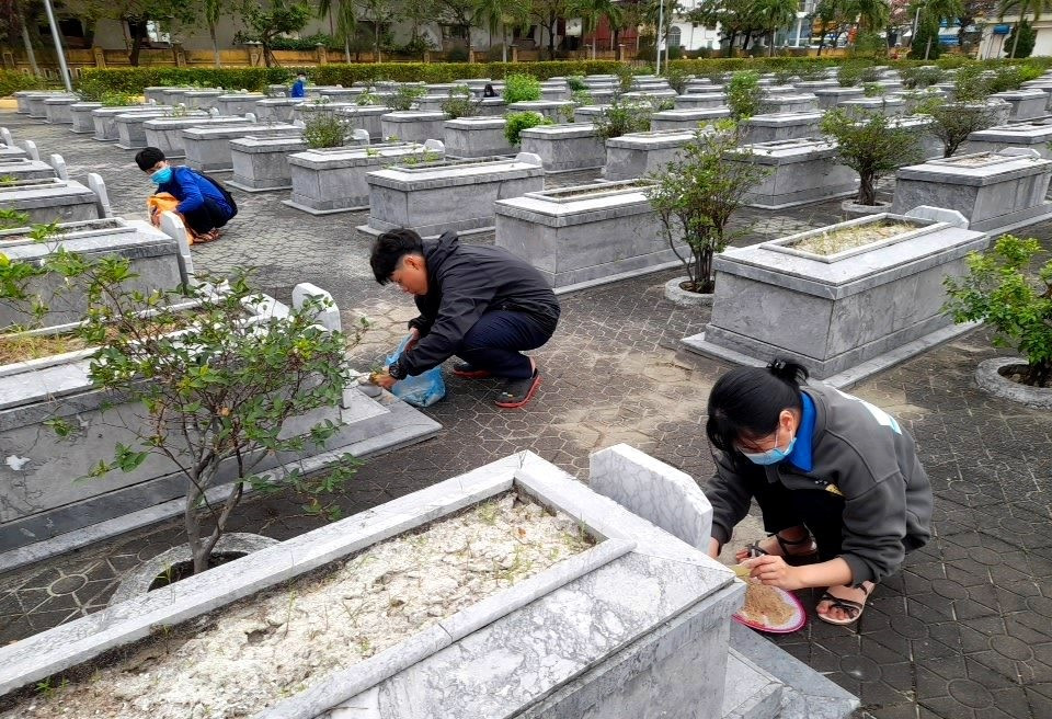 Học sinh Trường THPT Lê Quý Đôn tổ chức quét dọn và thay cát hơn 500 lư hương tại Nghĩa trang liệt sĩ TP.Tam Kỳ. Ảnh: Đ.N