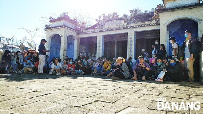 Ông Đặng Dùng kể chuyện Nam Ô với sinh viên báo chí Đà Nẵng tại miếu Âm linh. Ảnh: TRẦN TUẤN