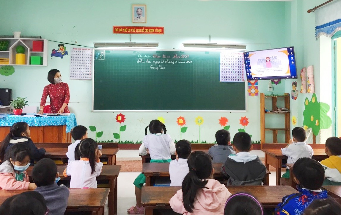 Giáo viên hướng dẫn học sinh về thông điệp “5K” và các biện pháp phòng chống dịch tại lớp trong buổi đầu tiên đến trường. Ảnh: C.N