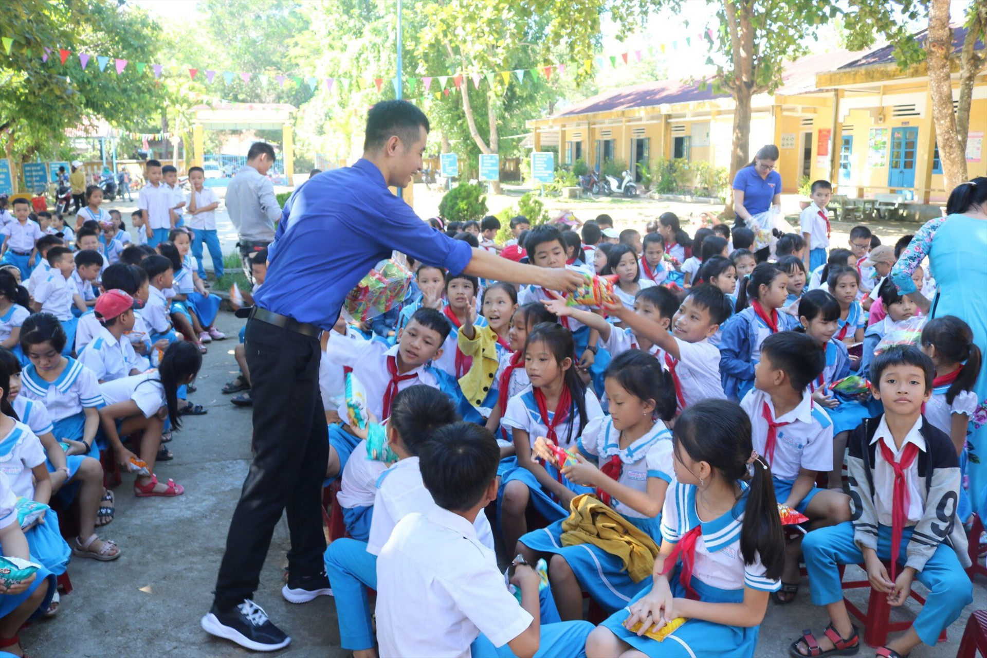 Anh Bảo tham gia ngoại khoá tiếng anh và phát kẹo, bánh cho học sinh tiểu học trên địa bản tỉnh Quảng Nam. Ảnh: QUỐC BẢO