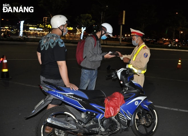 Ngoài kiểm tra nồng độ cồn, lực lượng Cảnh sát giao thông còn kiểm tra các loại giấy tờ. Ảnh: L.HÙNG