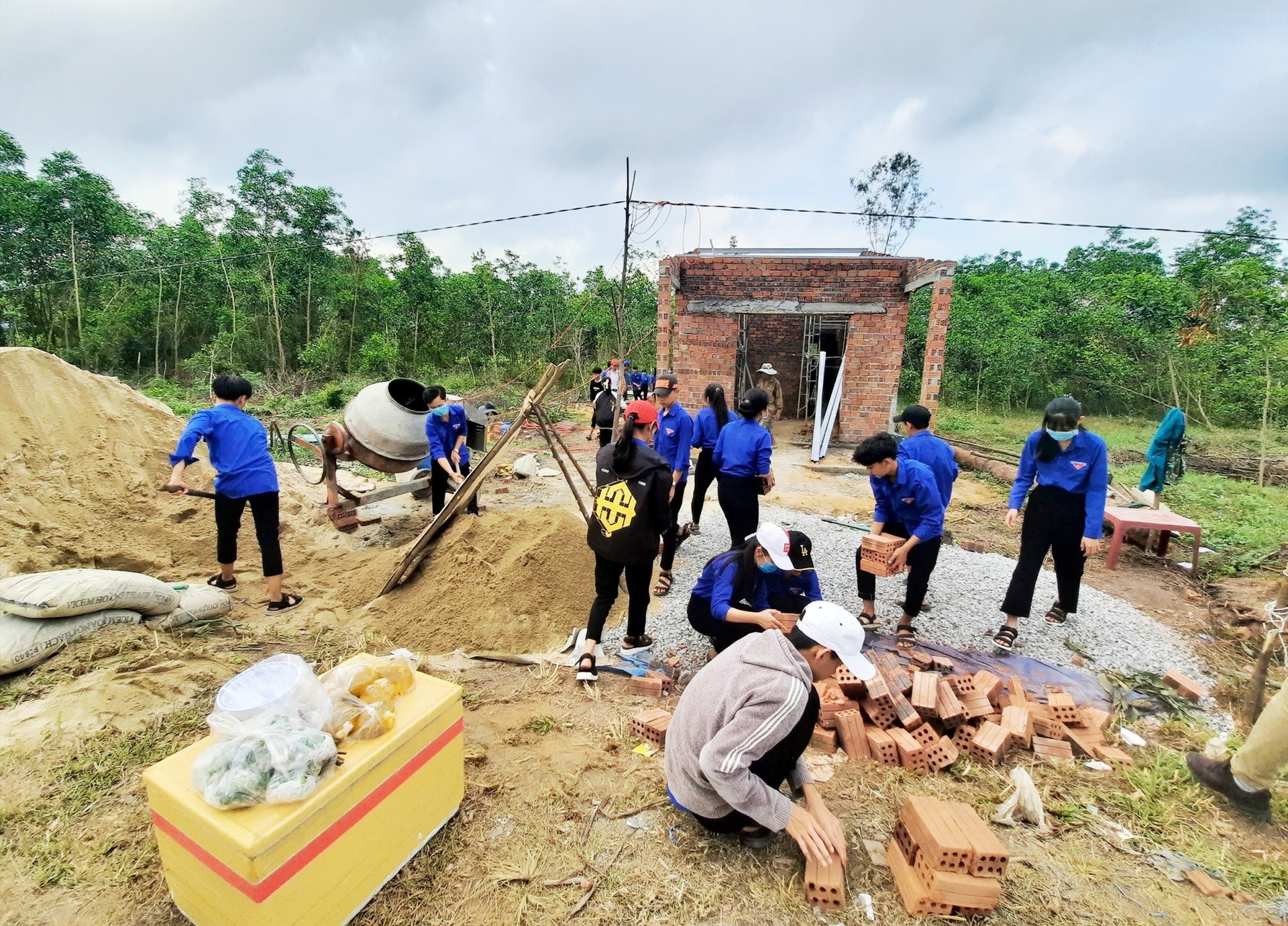Đoàn viên thanh niên góp sức xây dựng nhà cho gia đình bà Thái Thị Bảy. Ảnh: HỒ QUÂN