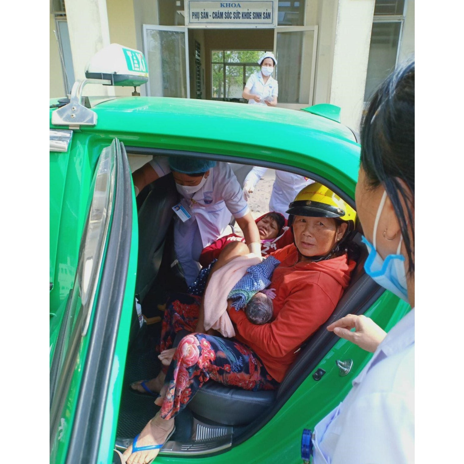 Nhân viên y tế tiếp nhận sản phụ và em bé để chăm sóc sau khi tài xế taxi hỗ trợ đỡ đẻ thành công. Ảnh: Q.T