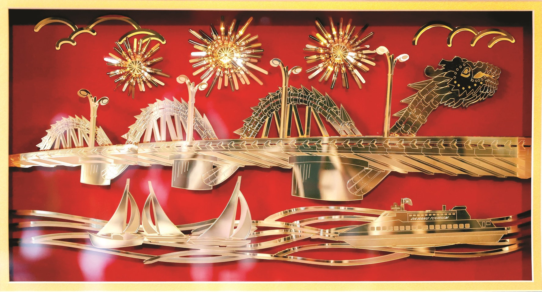 Cầu Rồng Đà Nẵng được cách điệu với pháo hoa, du thuyền. Sản phẩm tranh mạ vàng 3D này từng đoạt giải Ba cuộc thi thiết kế sản xuất sản phẩm lưu niệm du lịch, quà tặng phục vụ APEC năm 2017, do UBND TP. Đà Nẵng tổ chức.