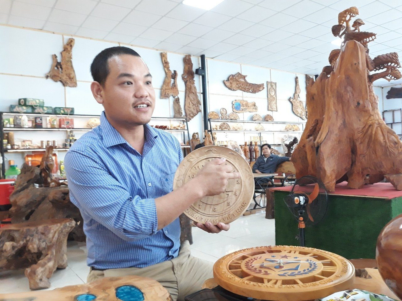 Ông Lê Hồng Thái giới thiệu sản phẩm mỹ nghệ bằng gỗ quế. Ảnh: C.N