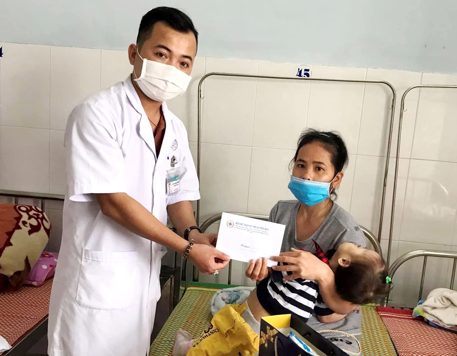 Đại diện Hội CTĐ Bệnh viện Đa khoa khu vực Quảng Nam trao tiền hỗ trợ cho bệnh nhân gặp khó khăn. Ảnh: T.H