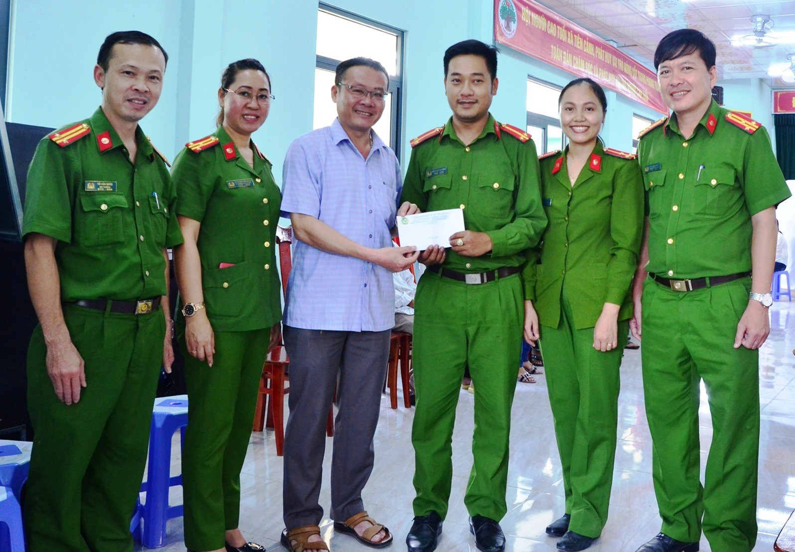 Chủ tịch UBND huyện Tiên Phước Trầm Quế Hương và lãnh đạo công an huyện tặng quà cho cán bộ, chiến sĩ làm CCCD tại xã Tiên Cảnh.