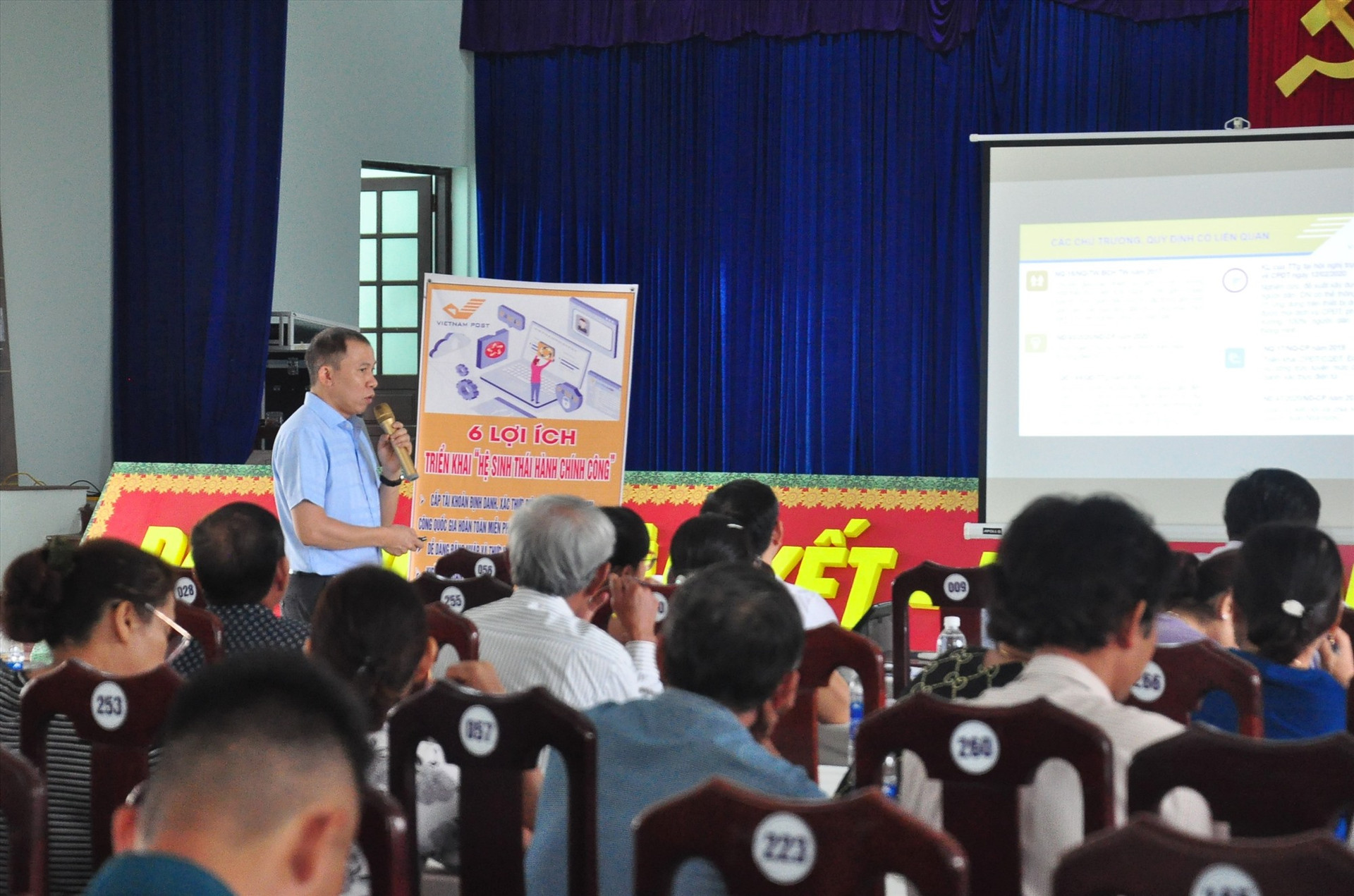 Cán bộ, người dân thị trấn Nam Phước được nhân viên bưu điện giới thiệu về “Hệ sinh thái hành chính công“. Ảnh: V.A