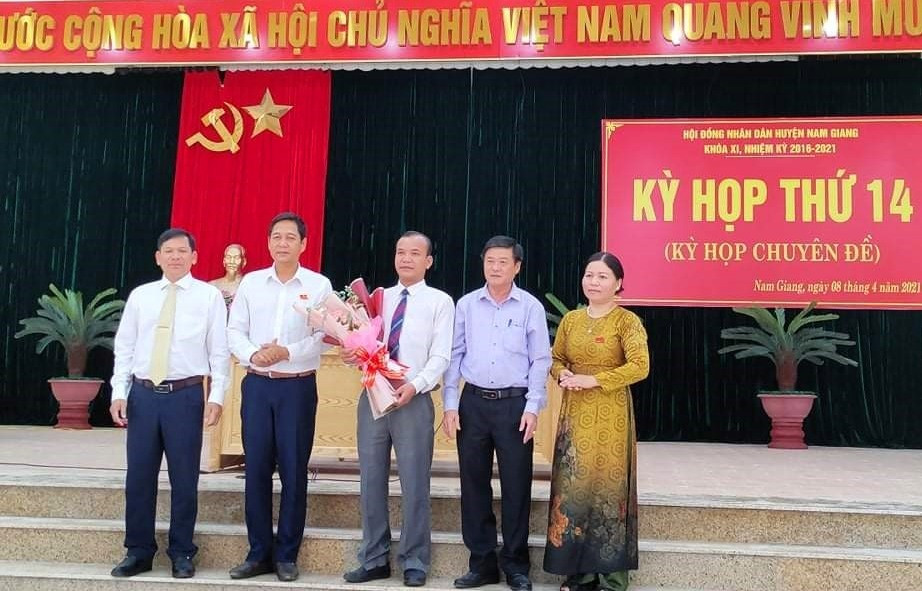 Lãnh đạo huyện Nam Giang tặng hoa chúc mừng ông Tơ Ngôl Với (ở giữa). Ảnh: Đ.N