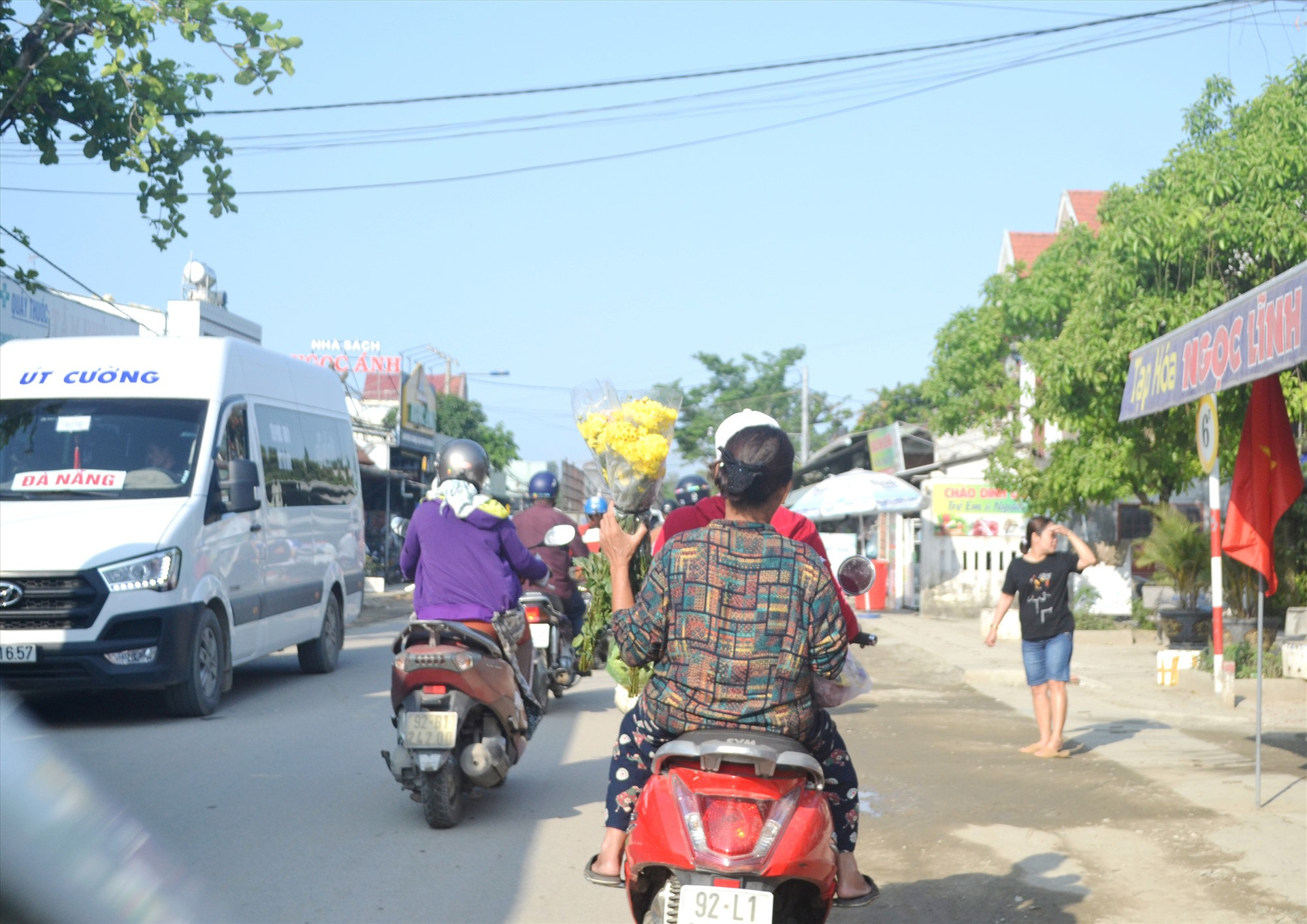 Quốc lộ 40B qua Phú Ninh đông đúc người đi lại dễ xảy ra va chạm, nhưng 2 người phụ nữ này không đội mũ bảo hiểm. Ảnh: C.T