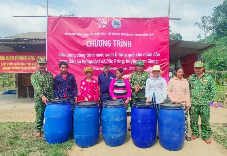 Ông Nguyễn Phương Linh, Phó giám đốc Văn phòng đại diện Tổng công ty AIA Quảng Nam tặng bồn chứa nước cho nhân dân cụm bản Pêtapoóc. Ảnh: THÁI TÙNG