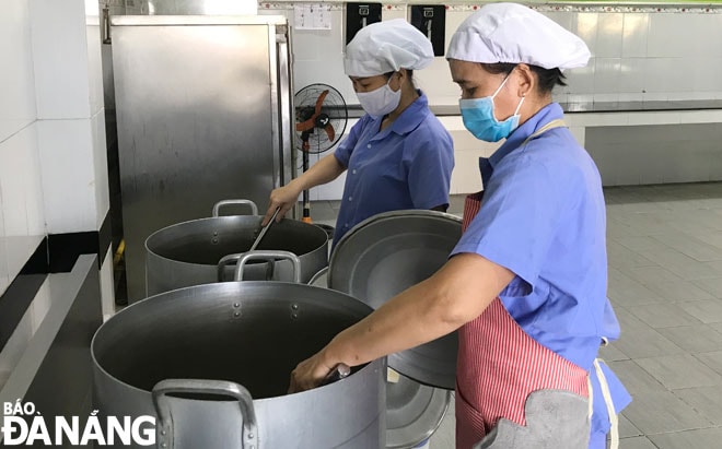 Nhân viên cấp dưỡng Trường Tiểu học Hai Bà Trưng (phường Nại Hiên Đông)  đang chế biến thức ăn cho học sinh bán trú, tuân thủ nghiêm các quy định về an toàn vệ sinh thực phẩm. Ảnh: M.QUẾ