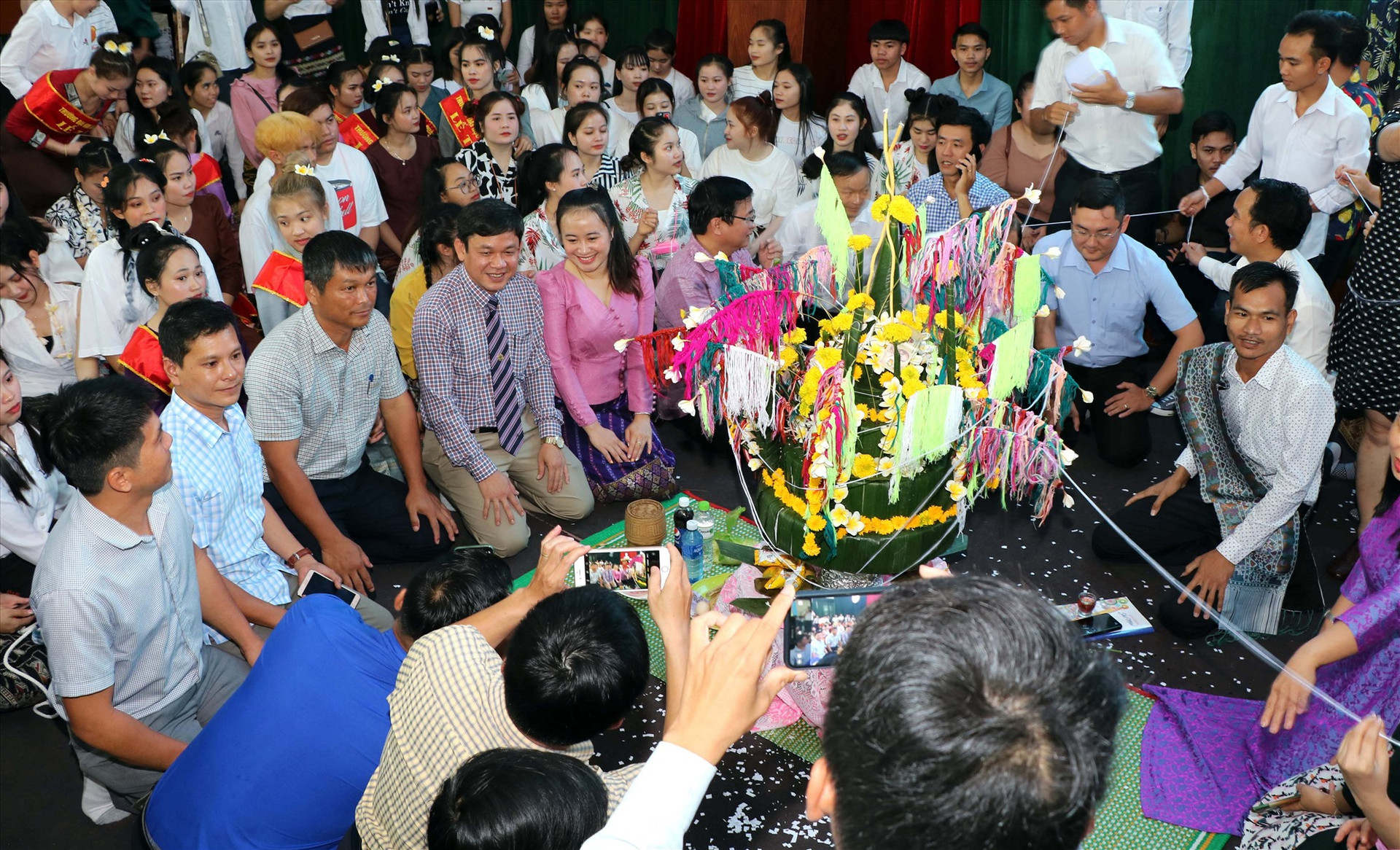 Các đại biểu tham gia nghi lễ mừng năm mới cùng với lưu học sinh Lào. Ảnh: CHÂU HÙNG.