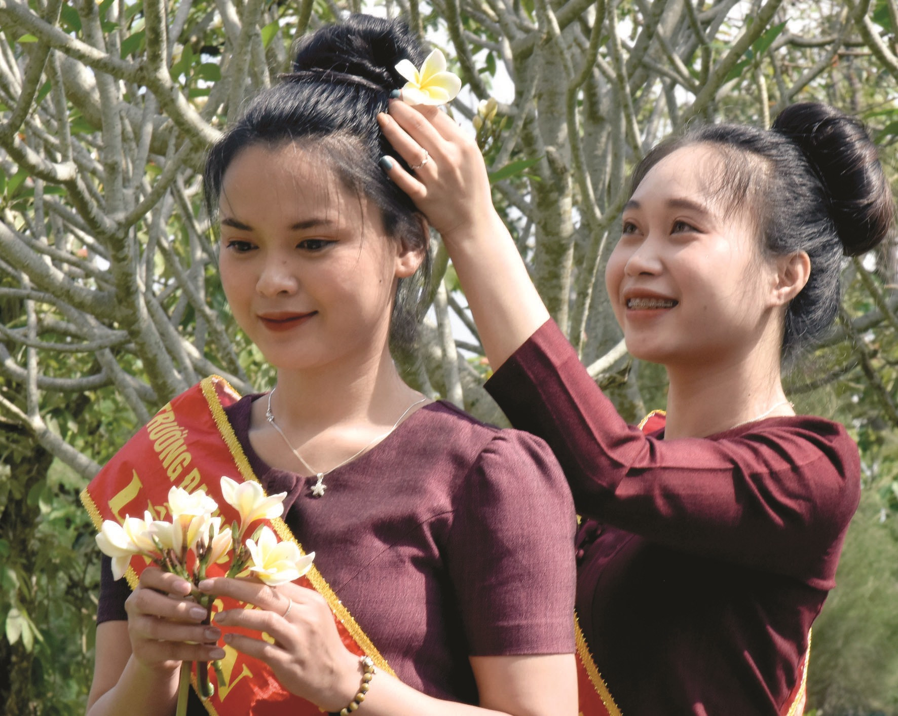 Các cô gái Lào Lùm trang sức hoa champa trên mái tóc.