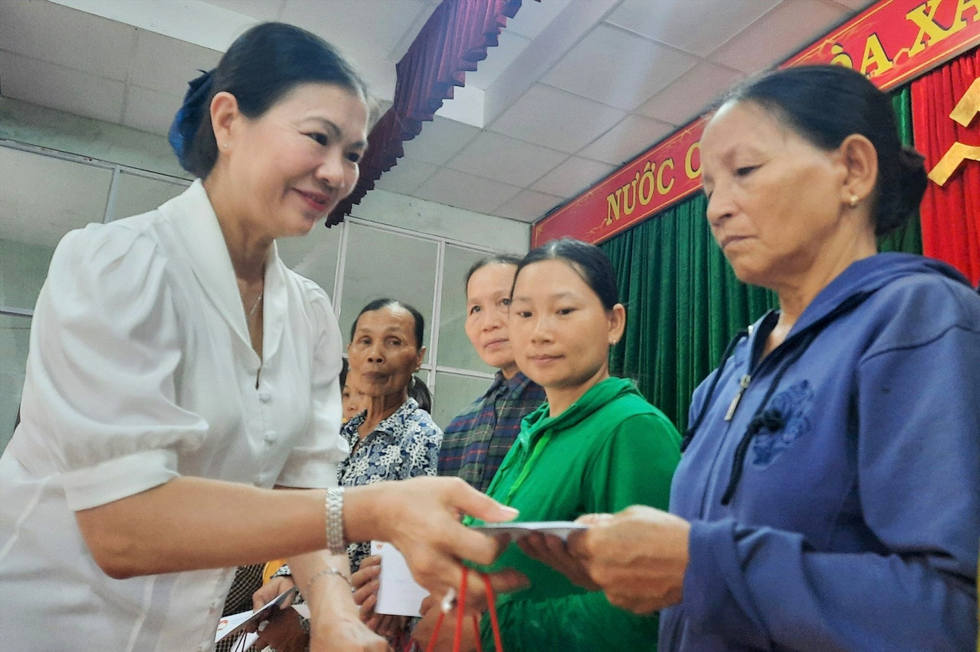 Bà Trương Thị Ngọc Ánh - Phó Chủ tịch Ủy ban Trung ương MTTQ Việt Nam tặng quà cho các hộ dân tham gia dự án. Ảnh: A.Q