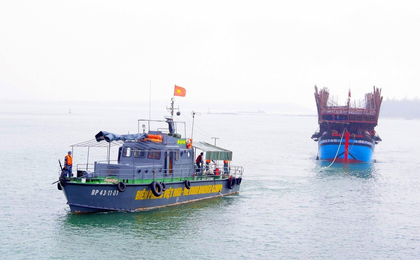 Bộ đội Biên phòng Quảng Nam lai dắt tàu câu mực của ngư dân bị nạn vào bờ. Ảnh: HỒNG ANH