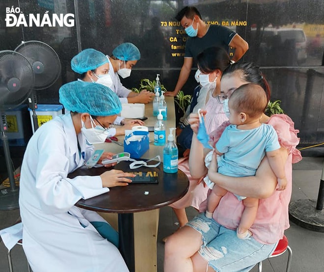 Bệnh nhân kê khai thông tin hồ sơ cá nhân trên máy tính bảng (iPad) trước khi đi vào bên trong Bệnh viện Gia đình. Ảnh: Đ.H.L