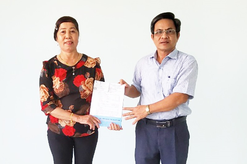 Bà Trần Thị Cúc nhận quyết định hưu trí từ cơ quan BHXH huyện Núi Thành.