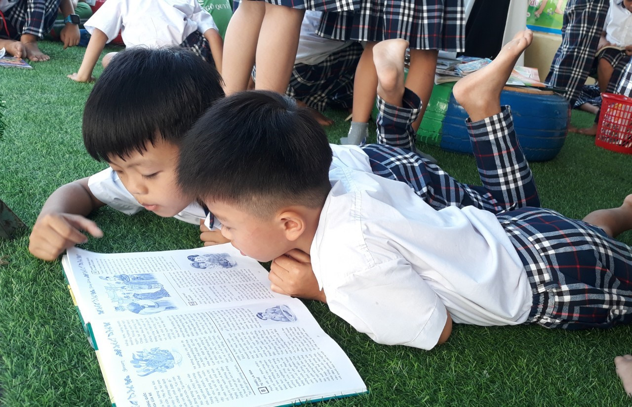 Học sinh Trường Tiểu học Ngô Quyền (Tam Kỳ) đọc sách tại thư viện cộng đồng trong sân trường. Ảnh: C.N