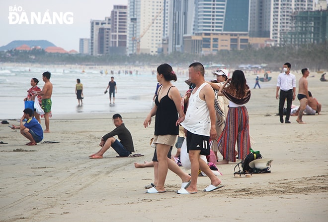 Đông đảo người dân, du khách đến các bờ biển, bãi tắm nhưng rất ít người mang khẩu trang. (Ảnh chụp chiều 27-4).