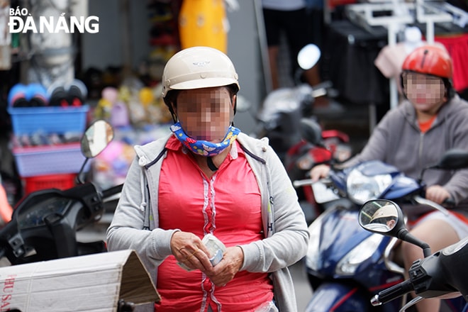 Nhiều người đi đường không mang khẩu trang, hoặc mang đối phó. (Ảnh chụp sáng 28-4)