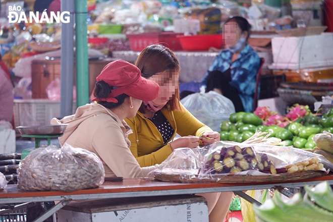 Một tiểu thương tại chợ Hòa Khánh (quận Liên Chiểu) không mang khẩu trang khi kinh doanh, buôn bán. (Ảnh chụp sáng 28-4).