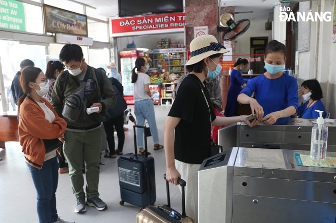 Trước khi vào khu vực chờ, nhân viên nhà ga sẽ kiểm tra việc khai báo y tế của hành khách. Ảnh: THÀNH LÂN