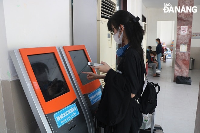 Hành khách in vé điện tử đã đặt trên hệ thống online ở Ga Đà Nẵng. Ảnh: VĂN HOÀNG