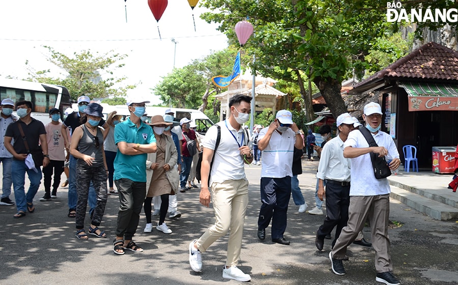 Tại các khu, điểm du lịch, lượng khách đến tham quan đông, công tác phòng chống dịch cũng được siết chặt. Trong ảnh: Du khách tham quan tại Di tích danh thắng Ngũ Hành Sơn. Ảnh: THU HÀ.