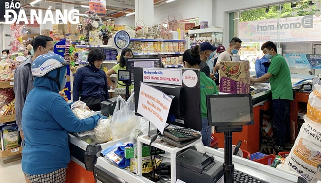 Khách hàng và nhân viên siêu thị Danavi Mart chấp hành nghiêm chỉnh việc đeo khẩu trang và sát khuẩn. Ảnh: QUỲNH TRANG.