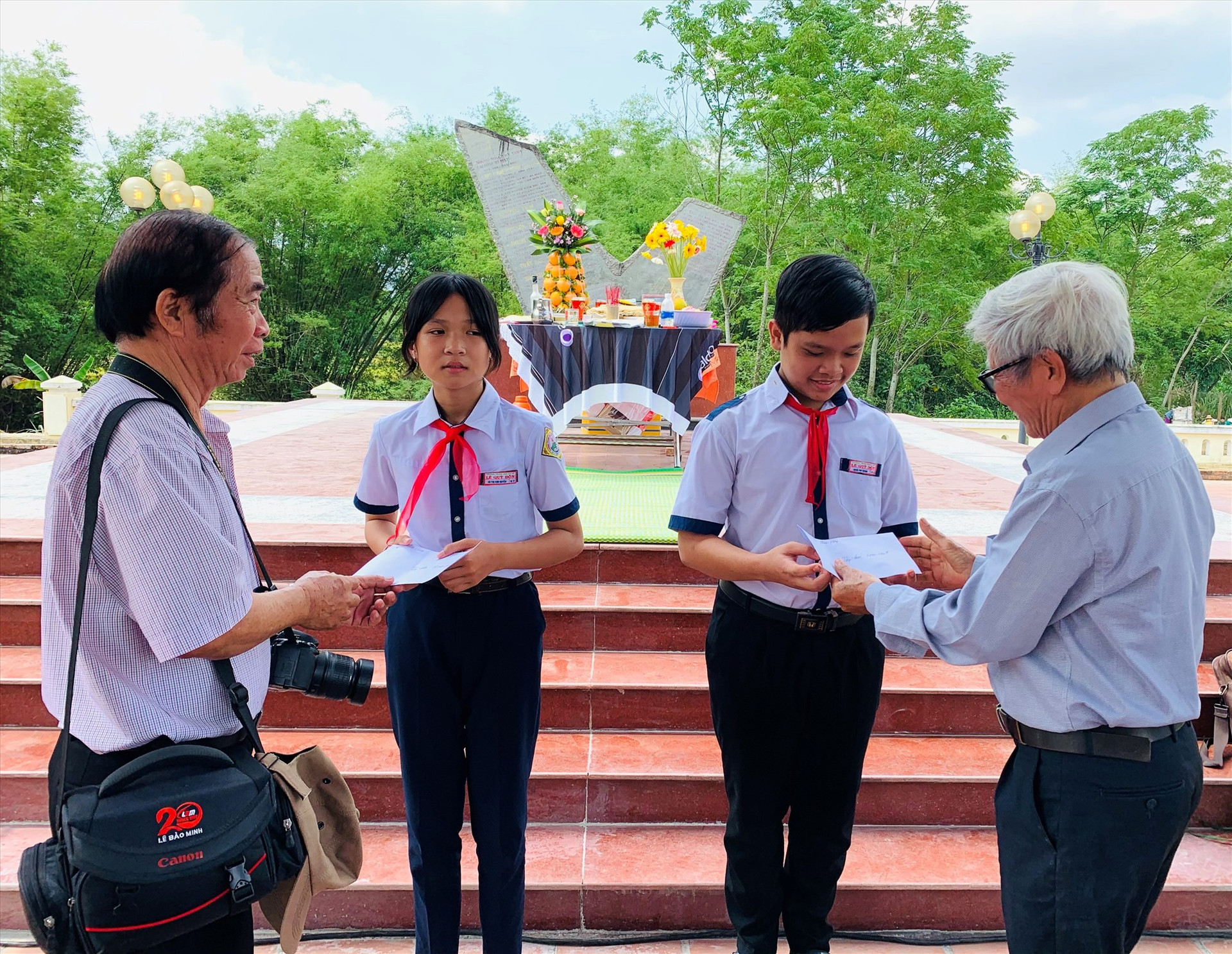 Các nhà văn, nhà báo ở Quảng Nam và Đà Nẵng tặng học bổng cho học sinh khó khăn của xã Duy Tân. Ảnh: T.S