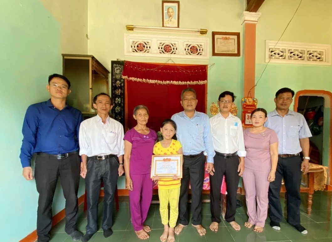 UBND huyện Tiên Phước khen thưởng cho em Nguyễn Ngọc Bảo Trân tại nhà em. Ảnh: D.L
