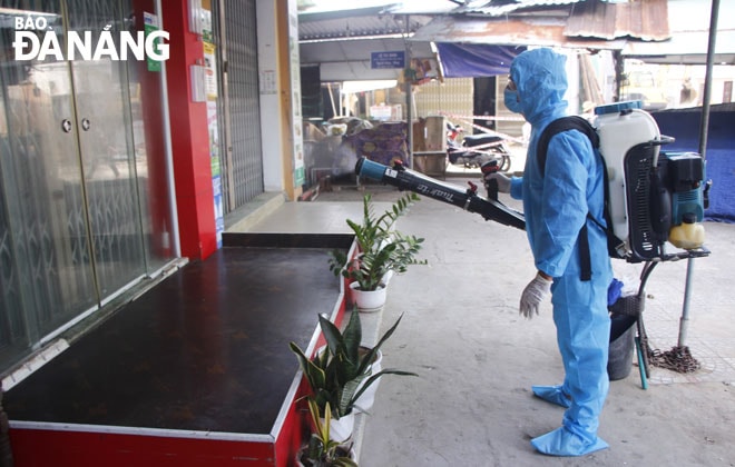 Nhân viên y tế quận Sơn Trà phun hóa chất khử khuẩn khu vực chợ Phước Mỹ. Ảnh: XUÂN DŨNG