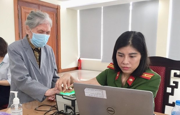 Cán bộ Đội 2, Phòng Cảnh sát quản lý hành chính về trật tự xã hội (Công an thành phố Hà Nội) phục vụ người dân đến làm thẻ căn cước công dân gắn chíp. (Ảnh: Nguyễn Thắng/TTXVN)