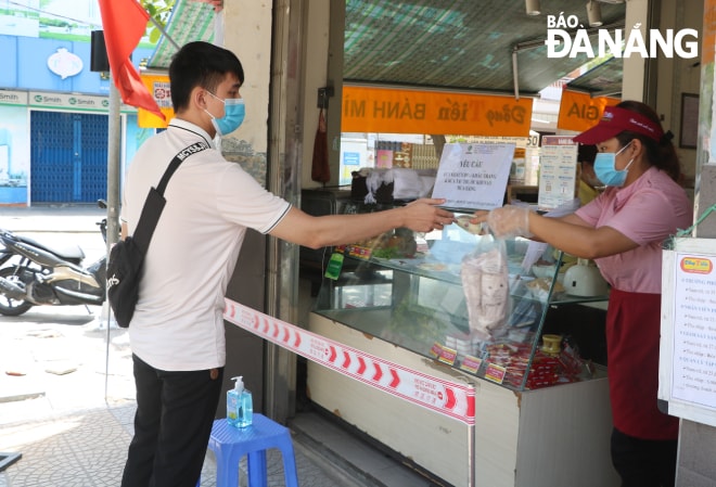 Một cơ sở bánh mì đường Nguyễn Chí Thanh giăng dây, yêu cầu khách hàng giữ khoảng cách khi mua hàng (ảnh chụp trưa 7-5). Ảnh:VĂN HOÀNG.