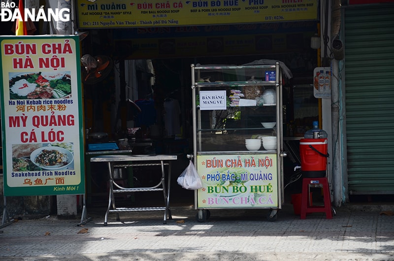 Các cửa hàng chủ động dán thông báo chỉ bán mang đi để khách hàng biết. Ảnh chụp trưa 7-5 đường Nguyễn Văn Thoại. Ảnh: THU HÀ
