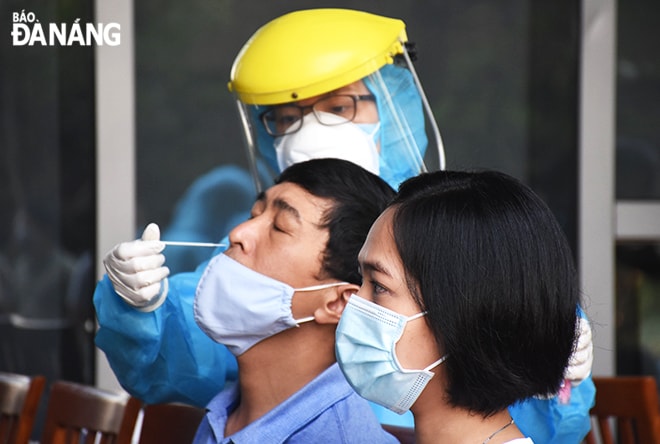 Nhân viên y tế lấy mẫu xét nghiệm cho người lao động làm việc tại Trung tâm Hành chính thành phố sáng 9-5. Ảnh: XUÂN DŨNG