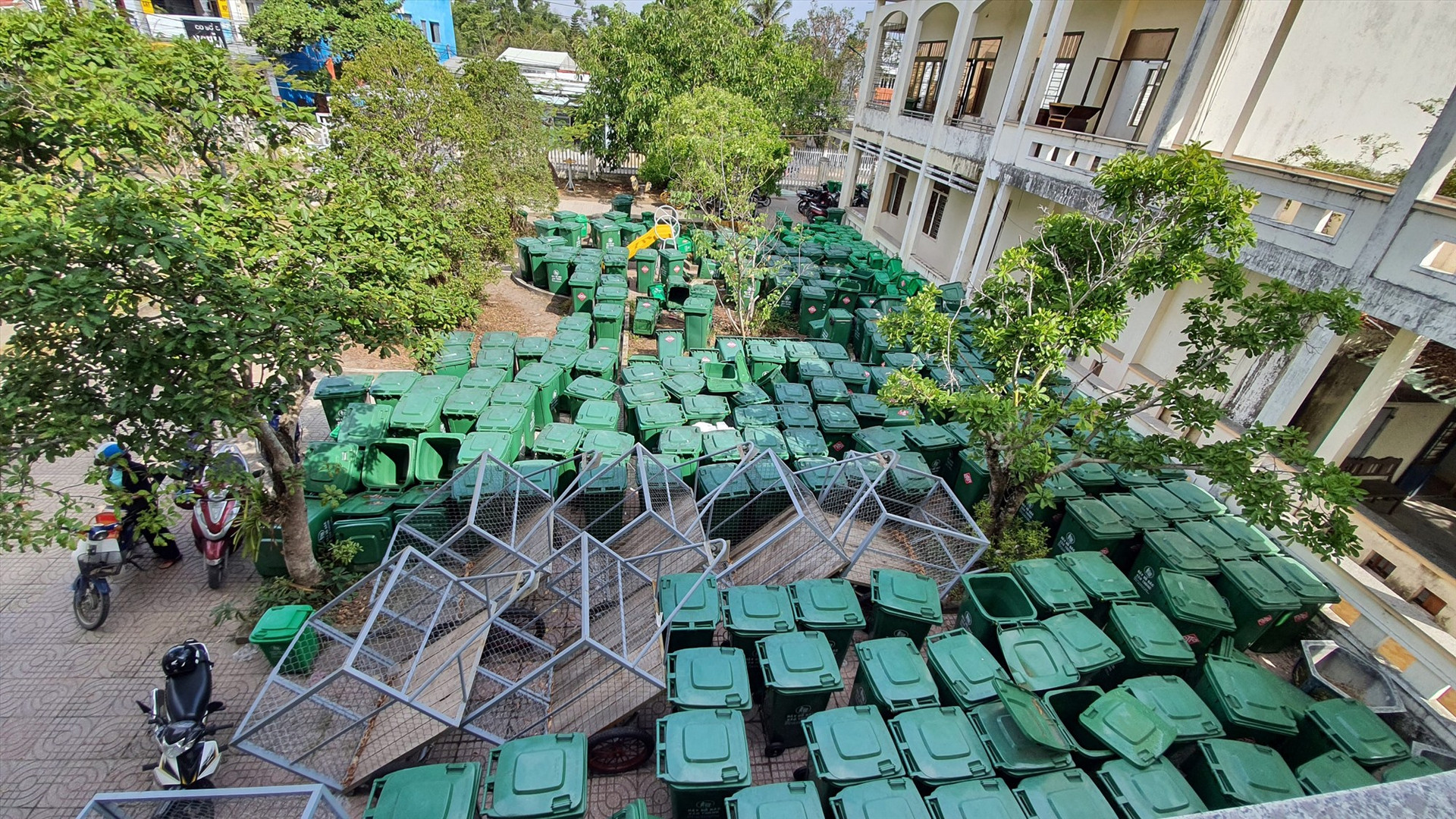 Rất nhiều thùng rác và một số xe thu gom cỡ nhỏ đã được mua sắm song vẫn đang tập kết tại trụ sở UBND xã Tam Hải. Ảnh: G.G