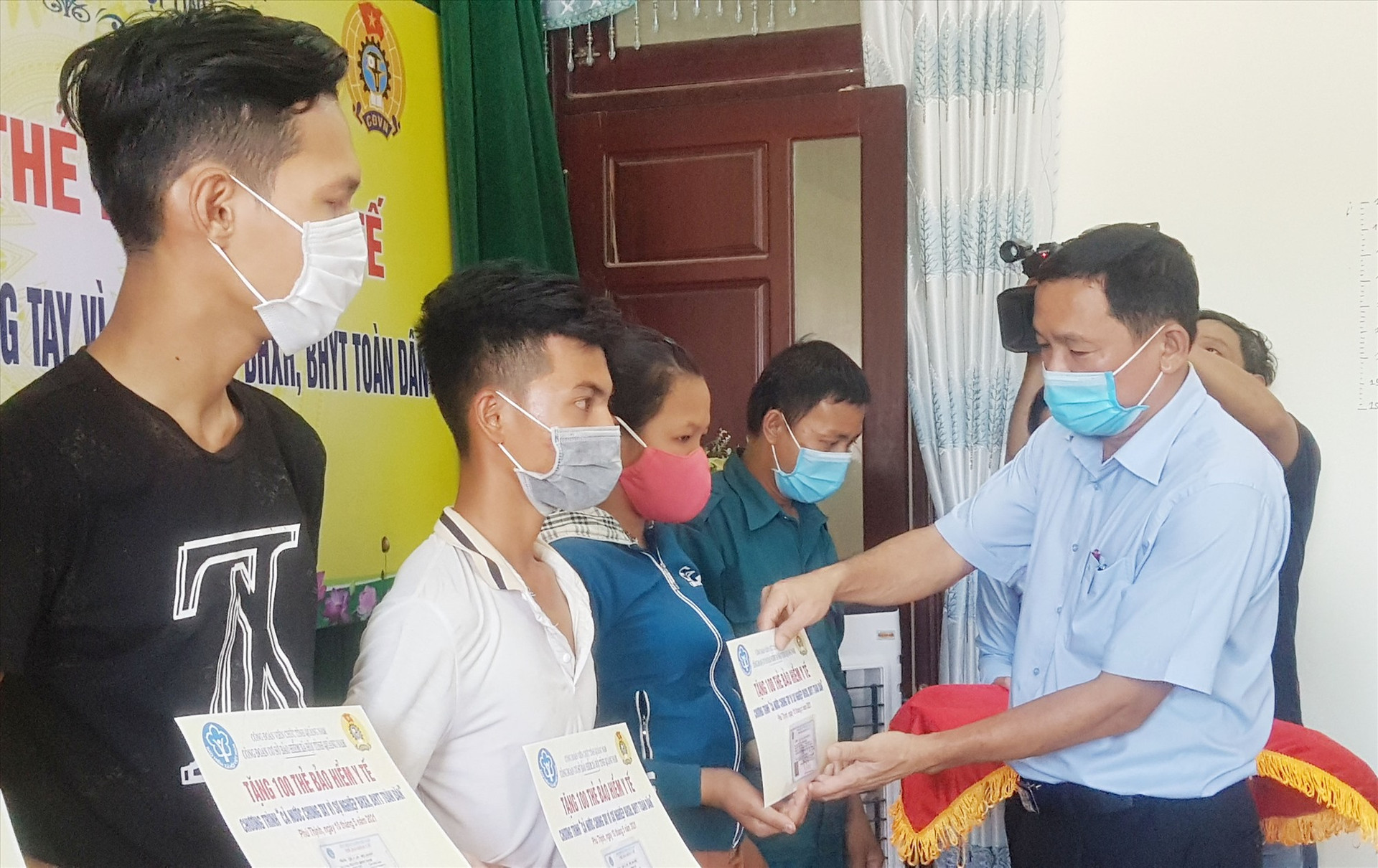 Giám đốc BHXH tỉnh Nguyễn Thanh Danh tặng thẻ BHYT cho người dân khó khăn của thị trấn Phú Thịnh. Ảnh: D.L