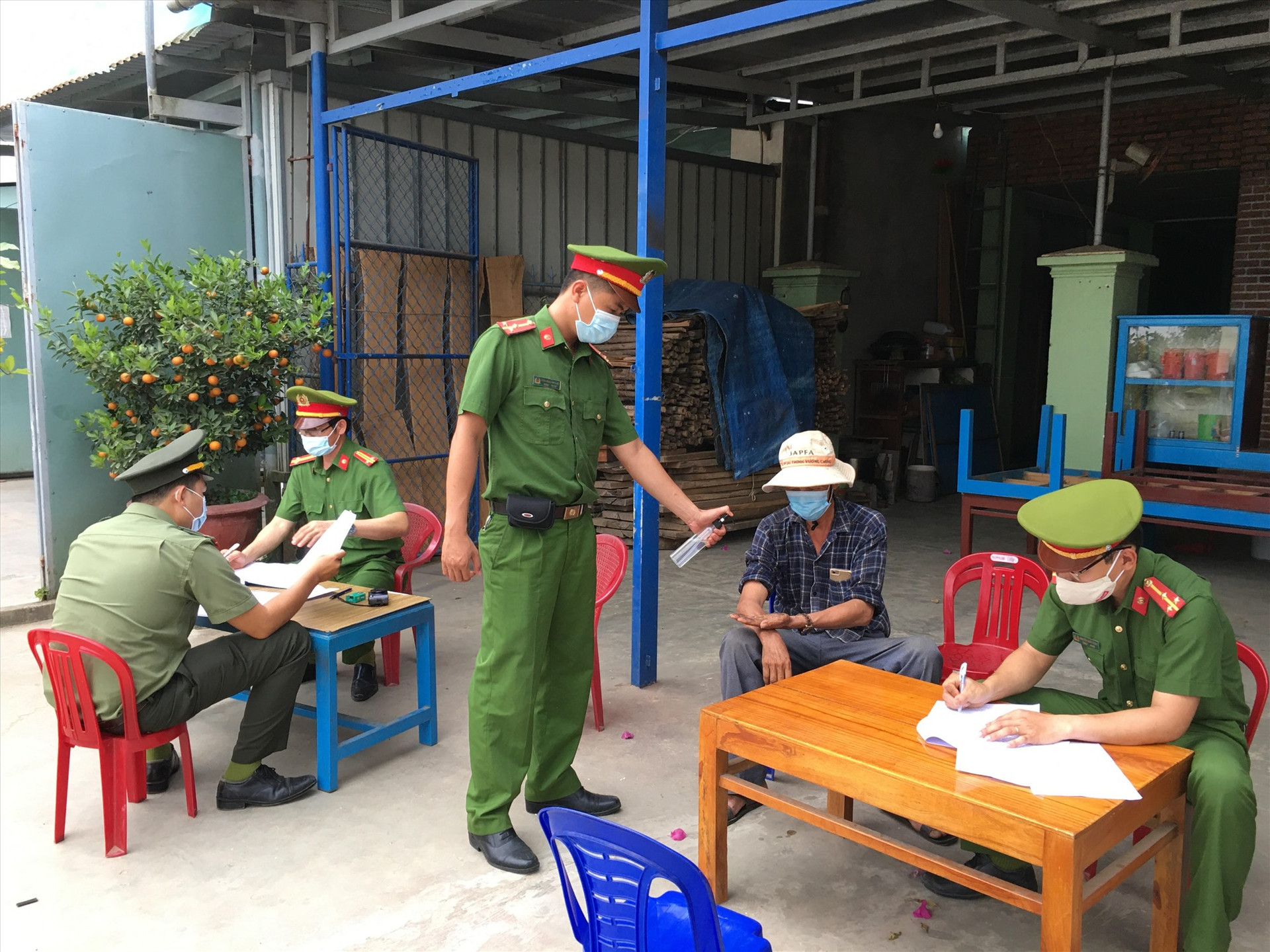 Công an huyện Phú Ninh lập biên bản xử phạt người vi phạm quy định đeo khẩu trang. Ảnh: H.C