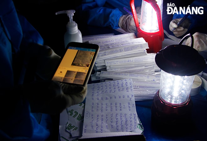 Chụp danh sách người lấy mẫu xét nghiệm gửi bộ phận nhập dữ liệu để đẩy nhanh quá trình tổng hợp trước khi mang mãu đến Trung tâm Kiểm soát bệnh tật thành phố. Ảnh: XUÂN DŨNG
