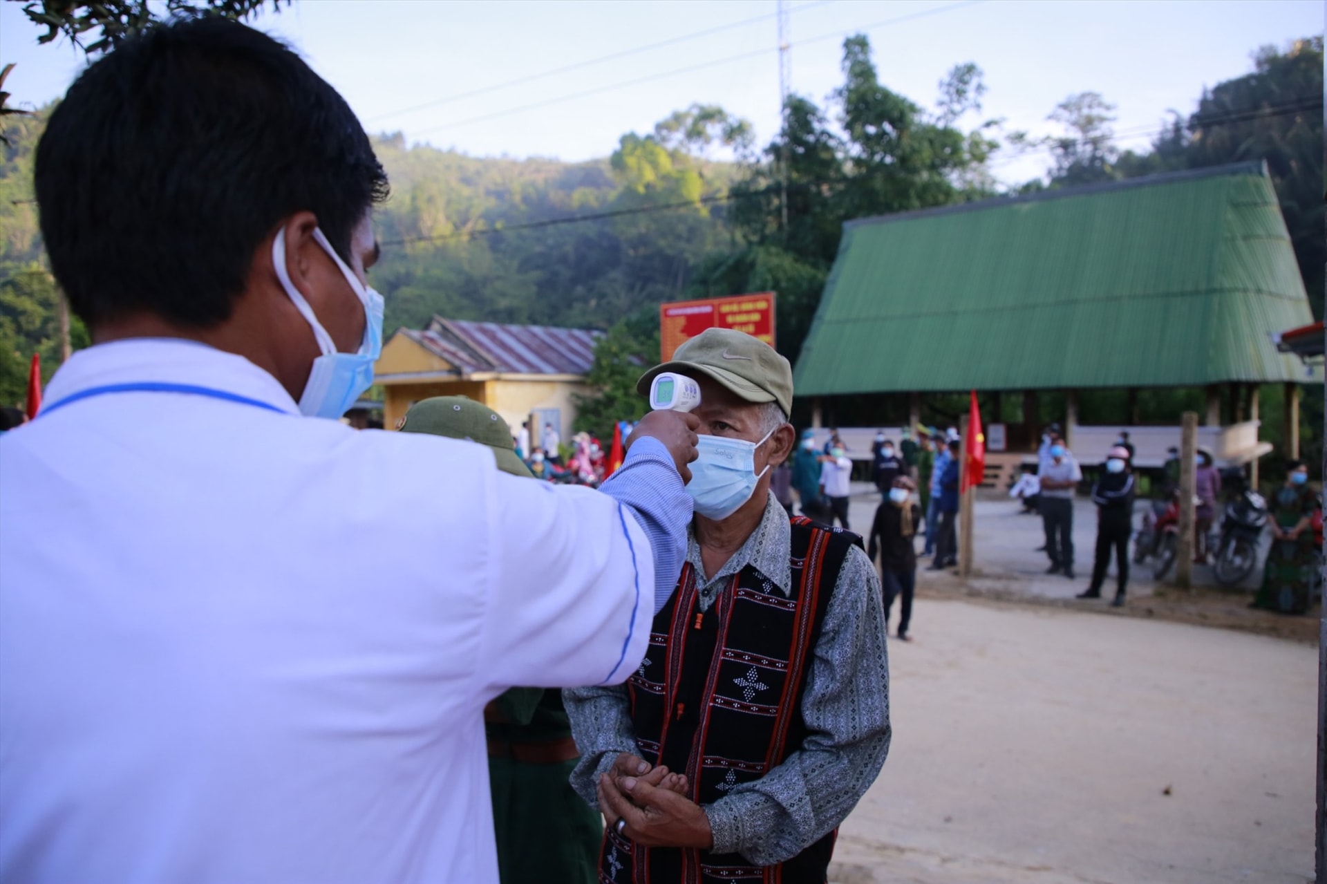 Người dân đo thân nhiệt trước khi vào điểm bầu cử. Ảnh: T.C