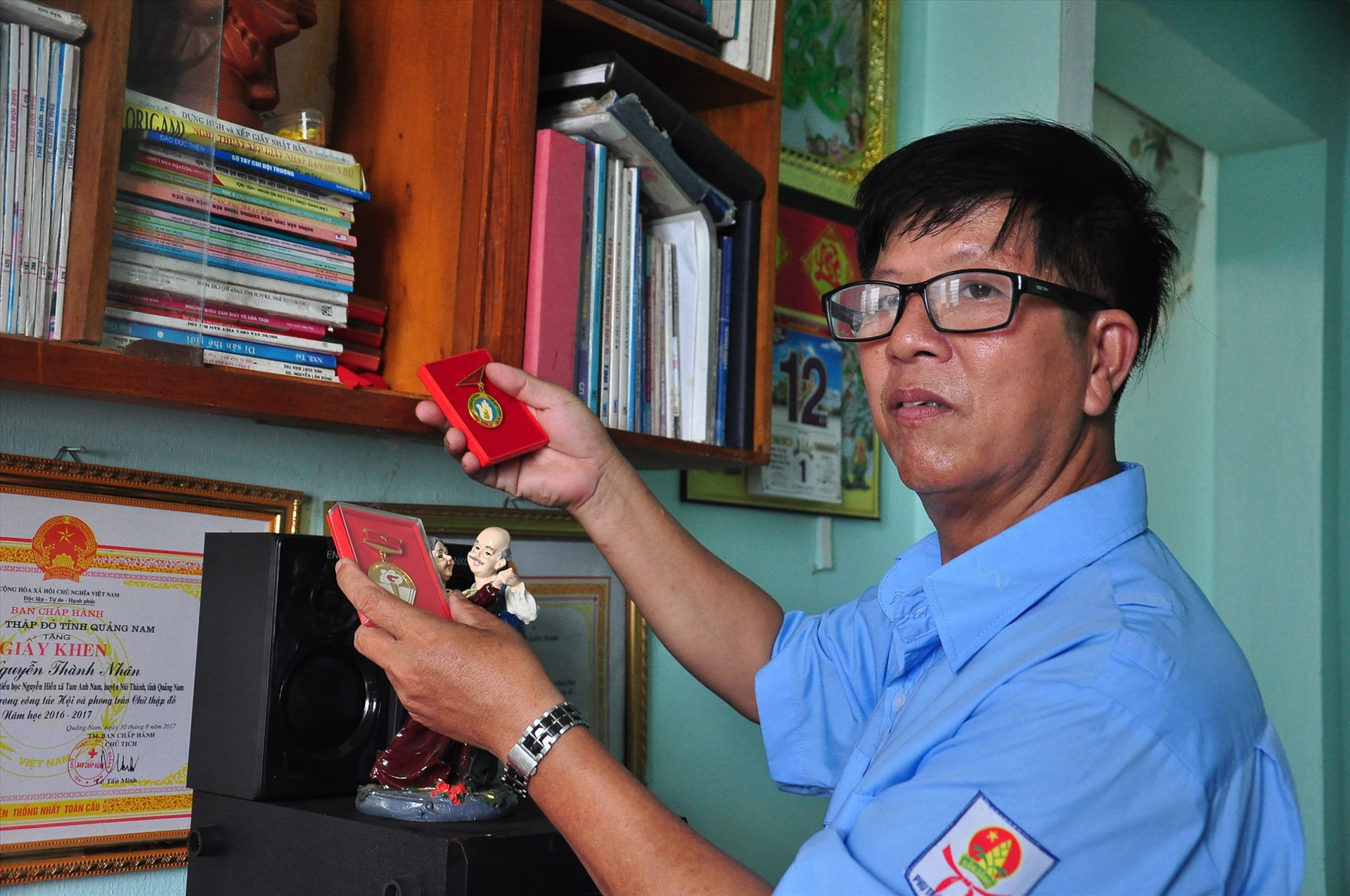 Thầy Nguyễn Thành Nhân lữu giữ cẩn thận những kỷ vật và các huy hiệu được khen tặng trong thời gian công tác của mình. Ảnh: VINH ANH