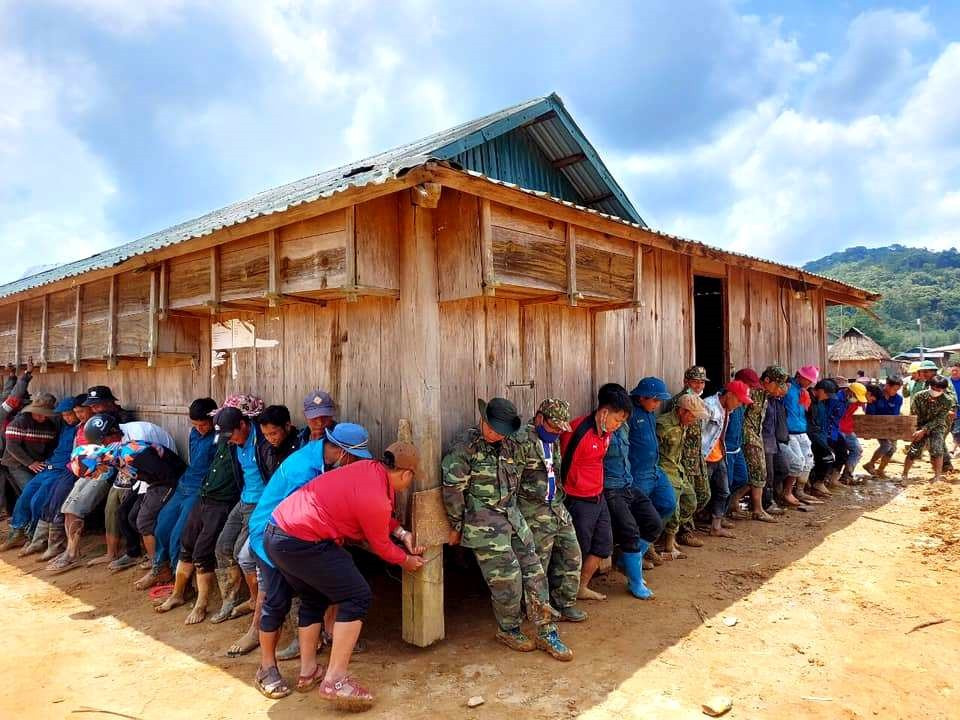 Chiến sĩ Đồn Biên phòng Ga Ry (Tây Giang) góp sức di chuyển căn nhà người dân địa phương khỏi điểm sạt lở. Ảnh: ALĂNG NGƯỚC